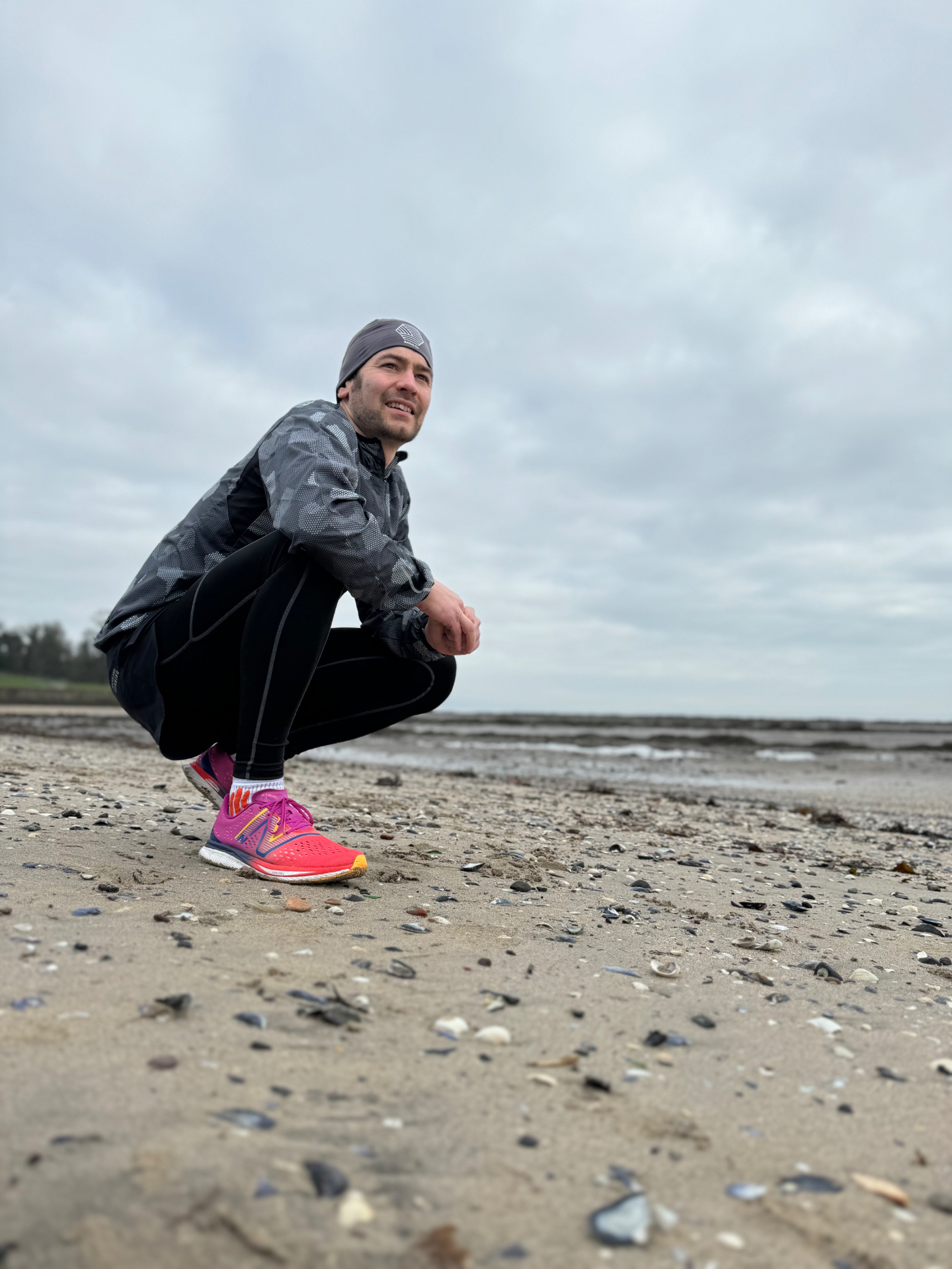 Nick crouched on a Northern Irish beach in running kit