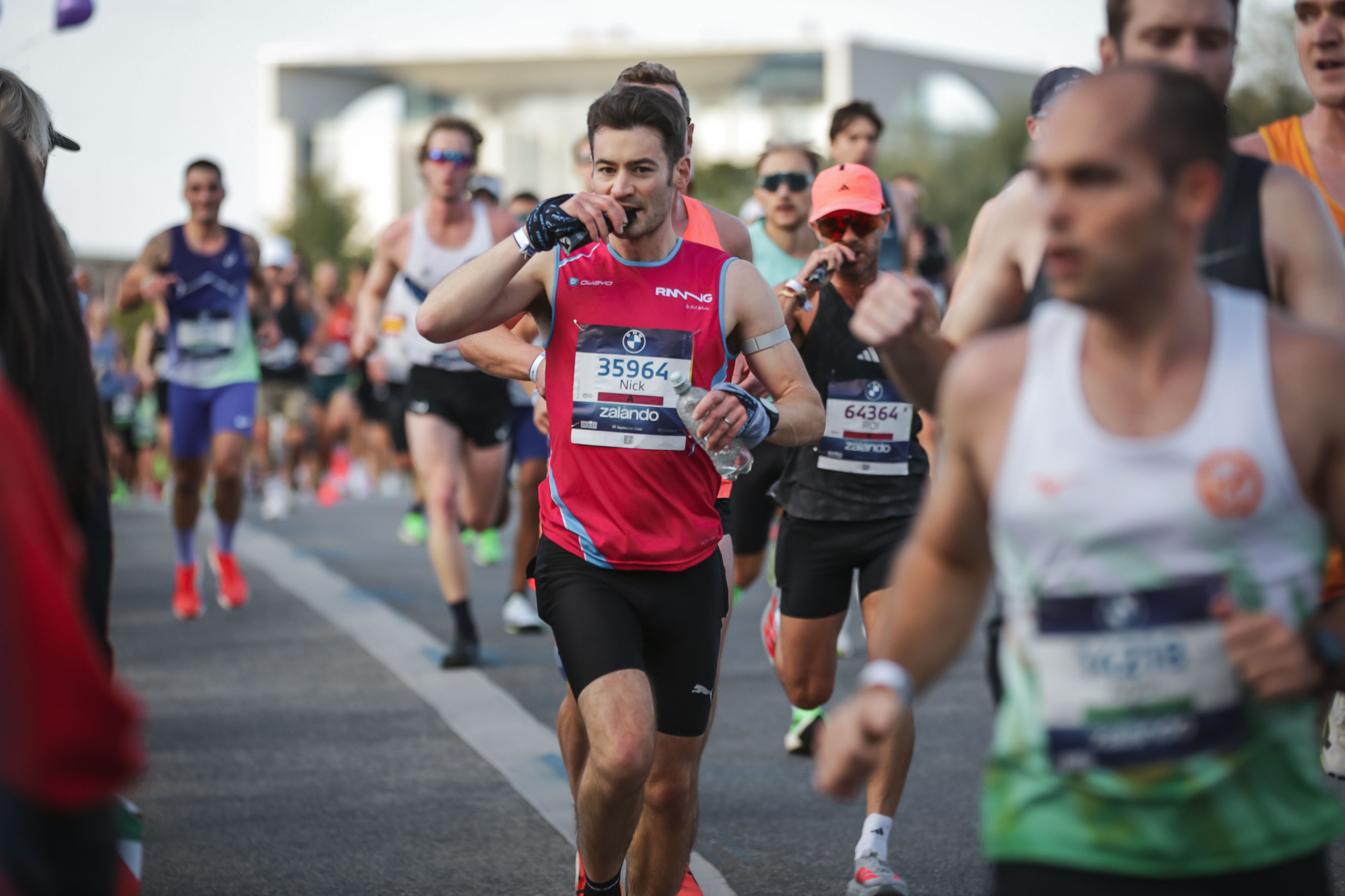 Nick Weston eating a gel and carrying a water bottle at Berlin Marathon